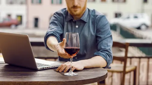 Uomo alla scrivania, con il suo pc e un calice di vino