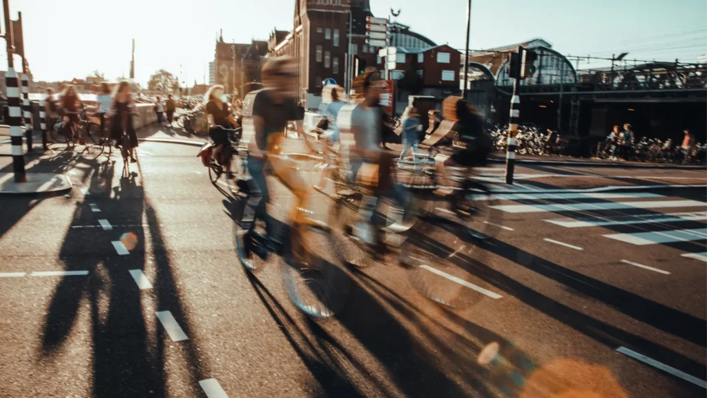 Persone in bicicletta, illuminate dalla luce del tramonto. 