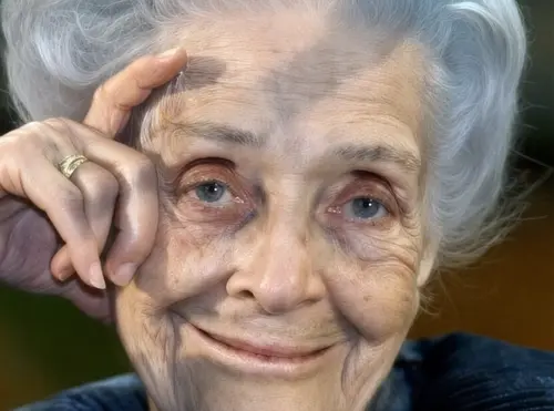 Rita Levi Montalcini sorridente, con la mano appoggiata alla tempia