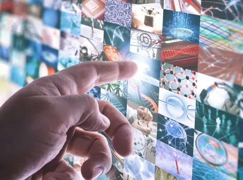 Mano che tocca un mosaico di immagini digitali su temi scientifici e tecnologici